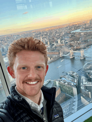 Man looking at camera with London attractions behind him