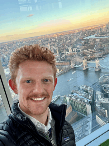 Man looking at camera with London attractions behind him