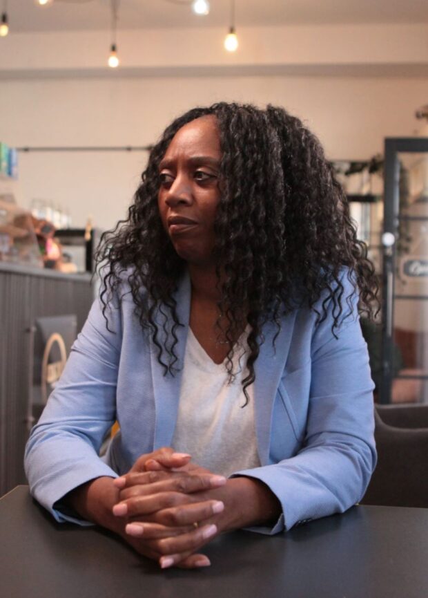 Photo of a person looking to the side, with hands clasped together