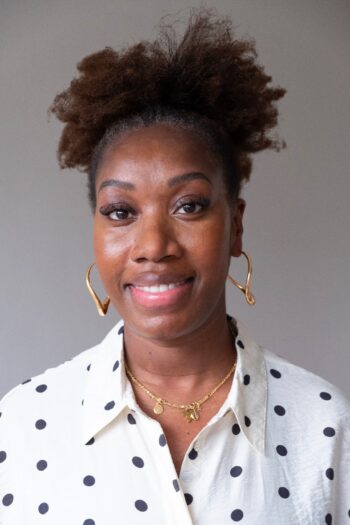 Image of a person's face and neck, featuring earrings and a shirt